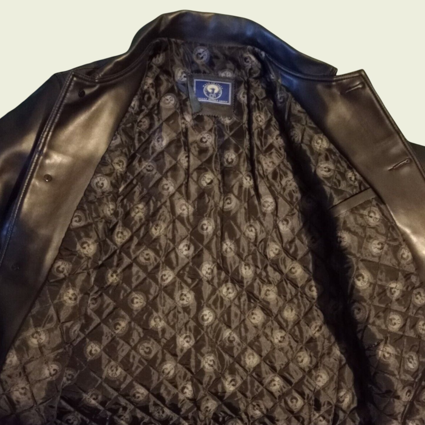 Black leather jacket with patterned lining and visible brand logo on a neutral background