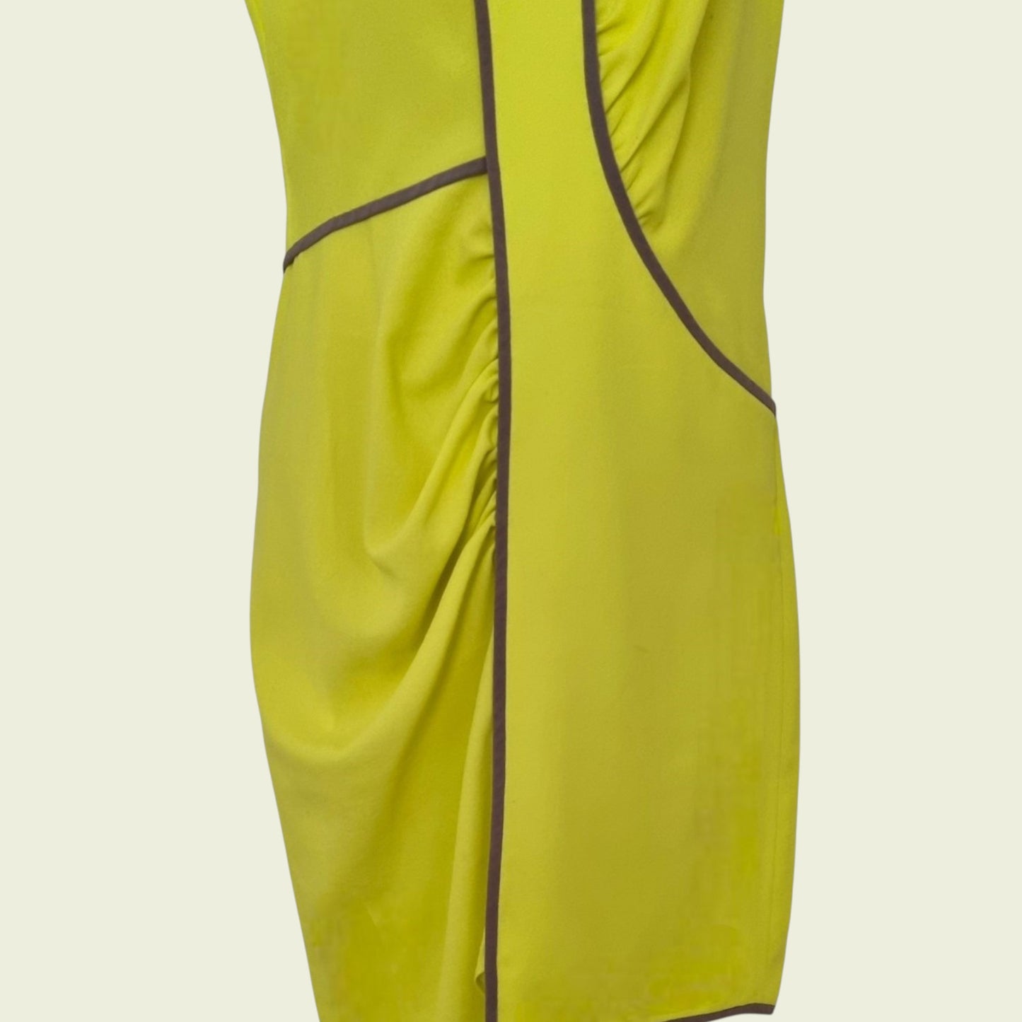 Yellow dress with brown piping on a beige background