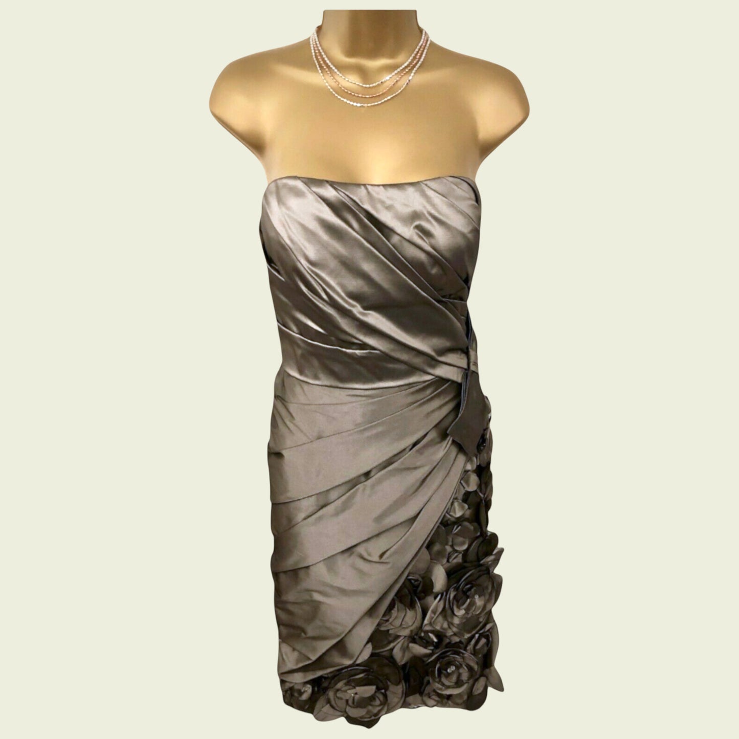 Mannequin wearing a gray strapless dress with floral details on a beige background