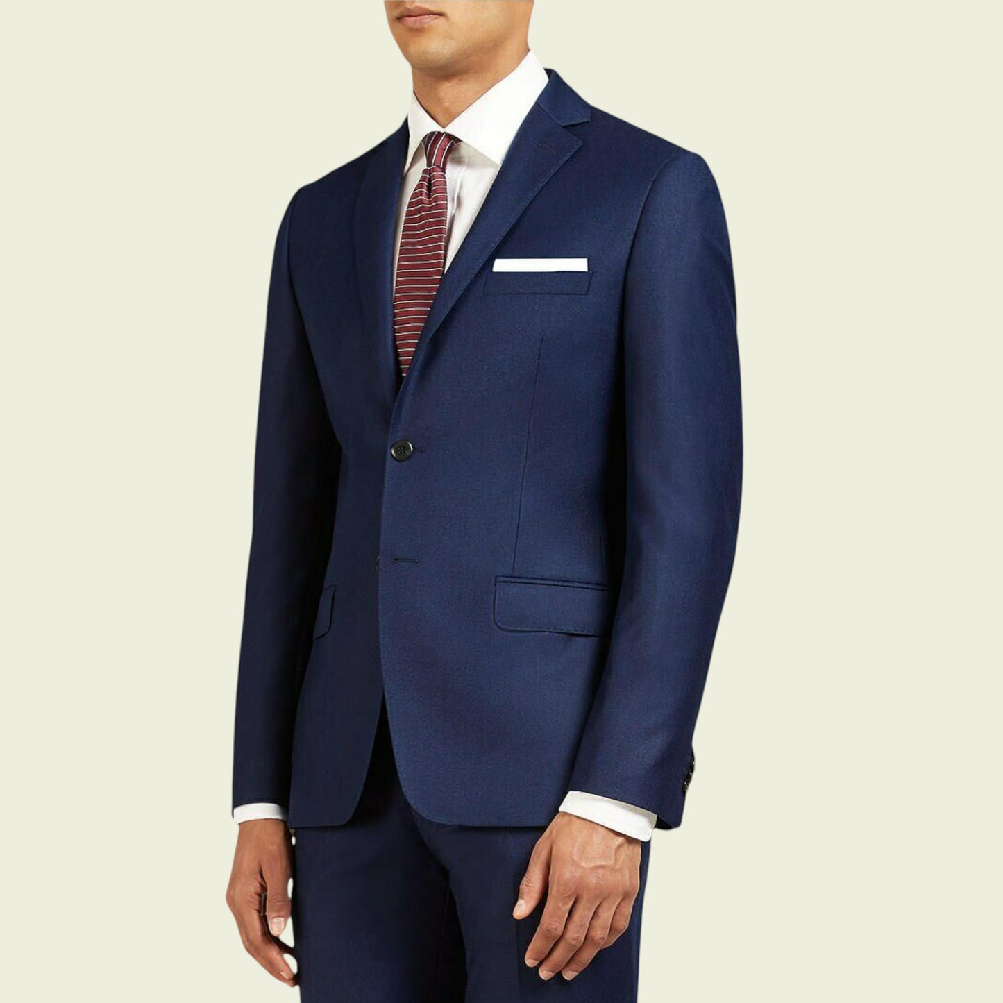 Navy blue suit with a white shirt and patterned tie on a beige background