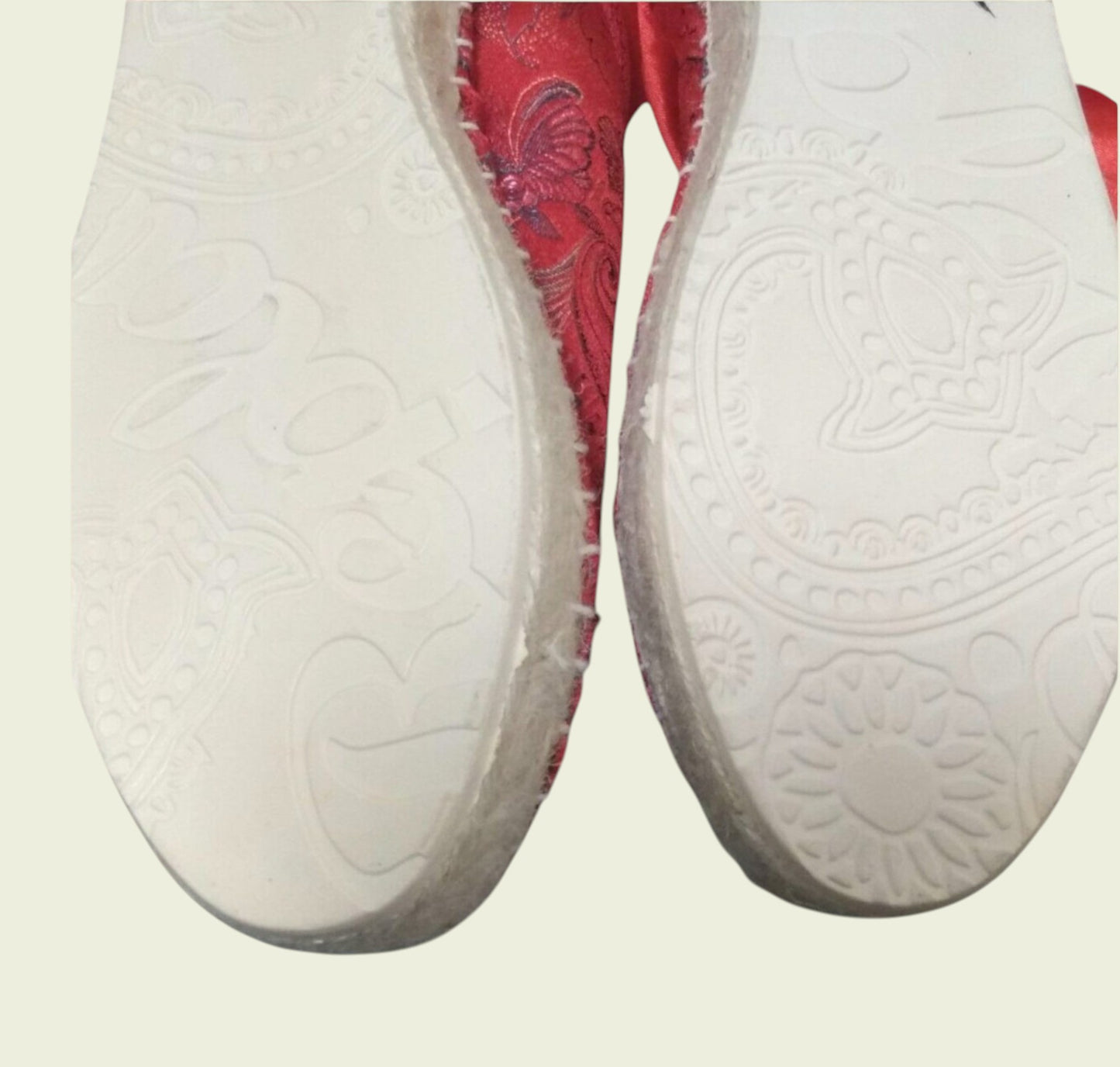 Red shoes showing white sole on a light gray background