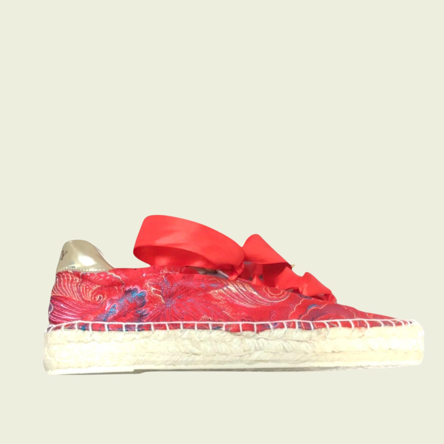 Red sneaker with a large bow on a light gray background