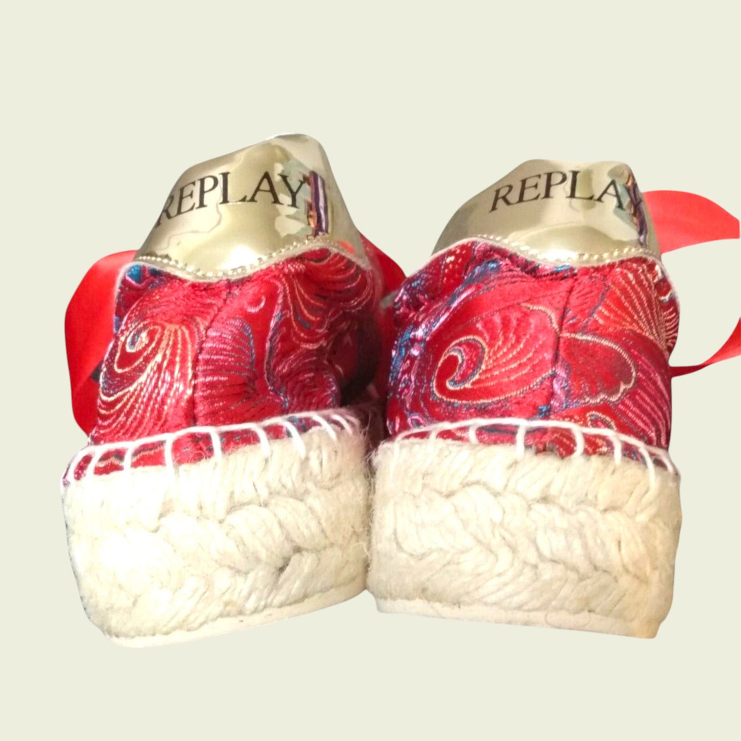 Red patterned shoes with white soles and 'REPLAY' branding on a light background