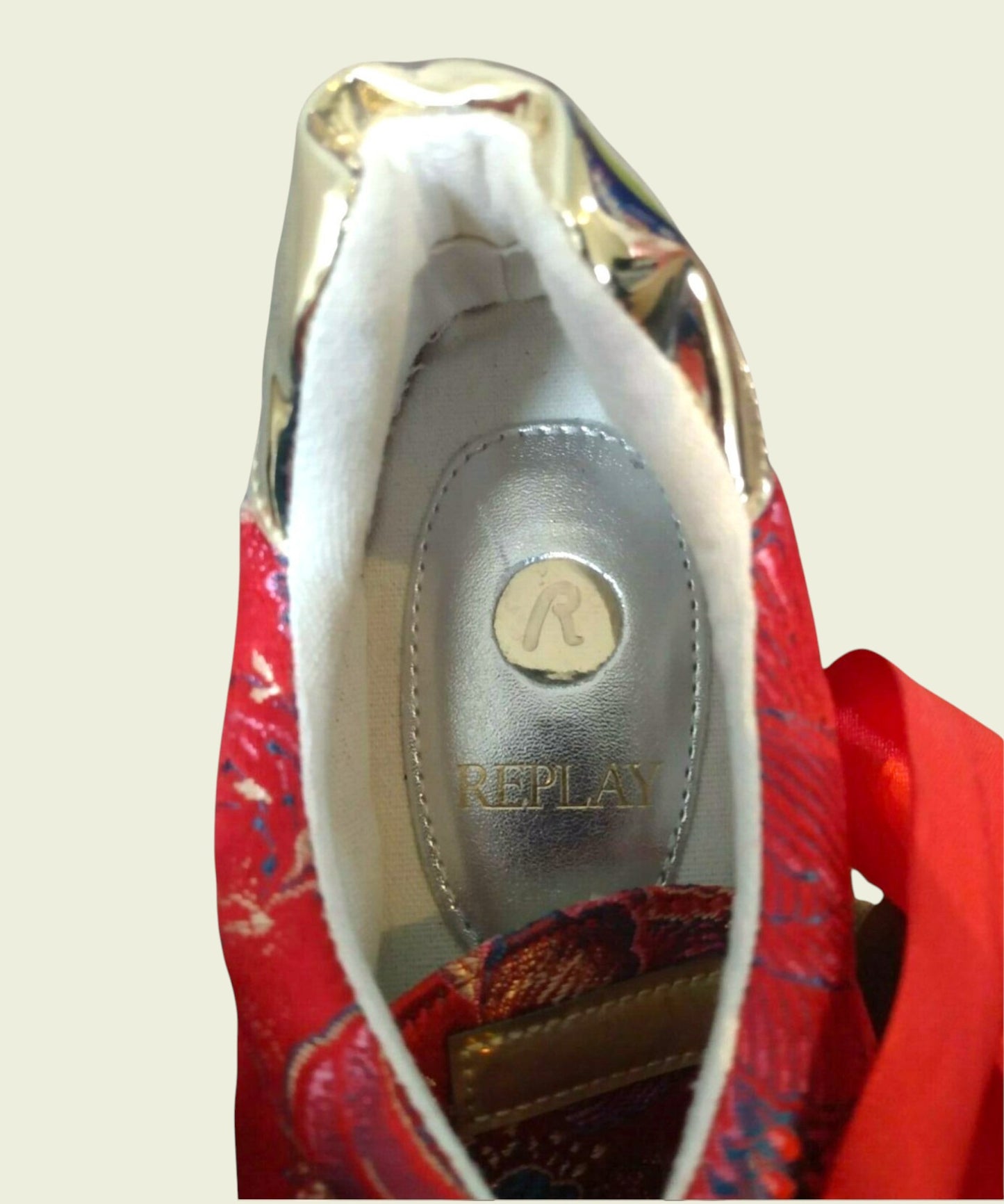 Close-up of a red shoe with 'Replay' branding on the sole.