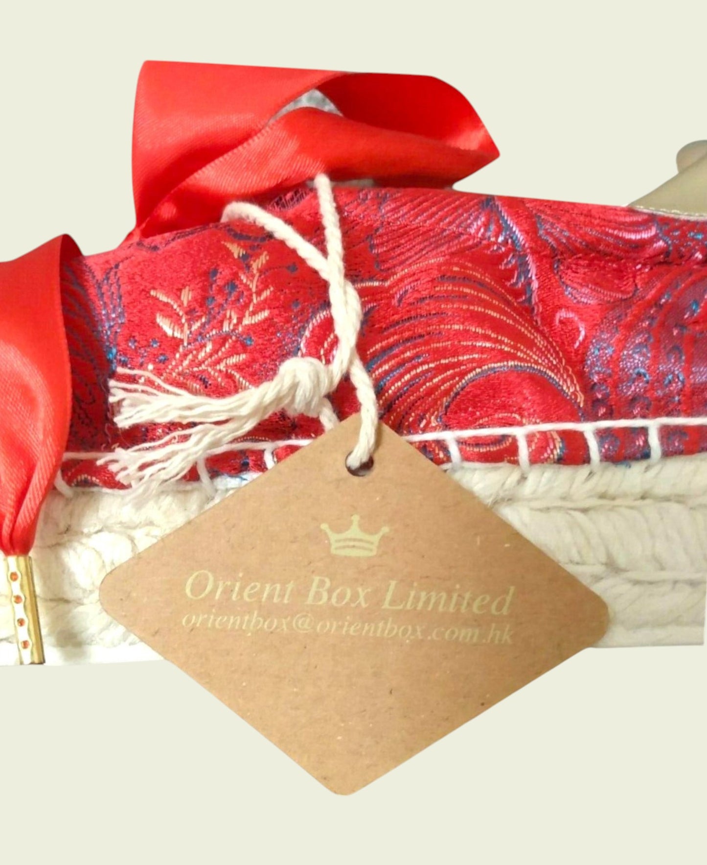 Red fabric with floral patterns and a 'Orient Box Limited' tag on a light background