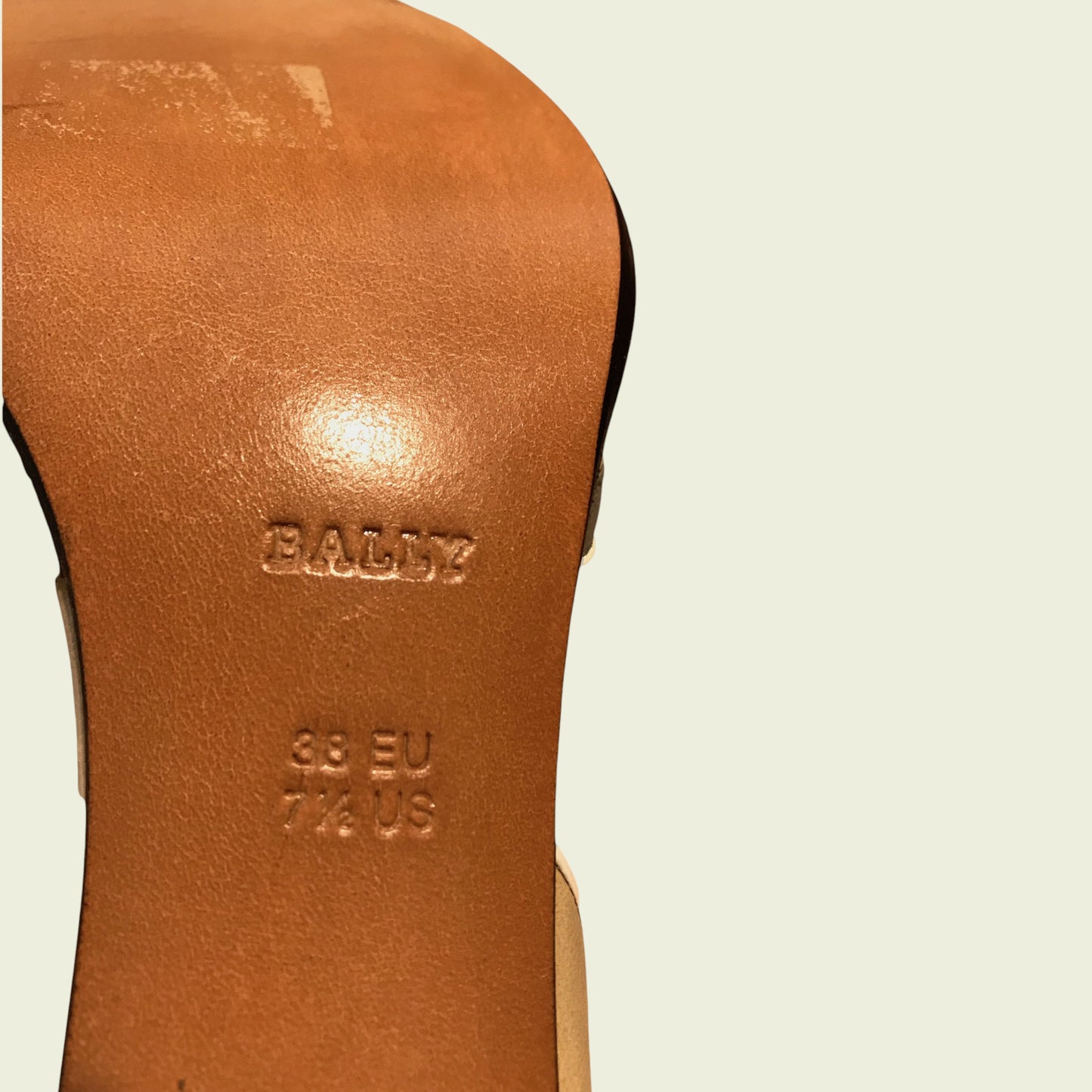 Close-up of a brown leather shoe sole with 'Bally' branding on a light beige background.