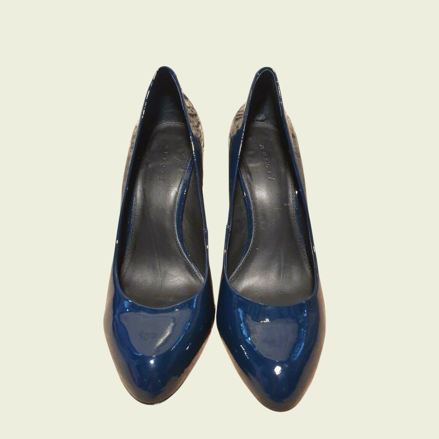 Pair of blue high-heeled shoes on a light beige background