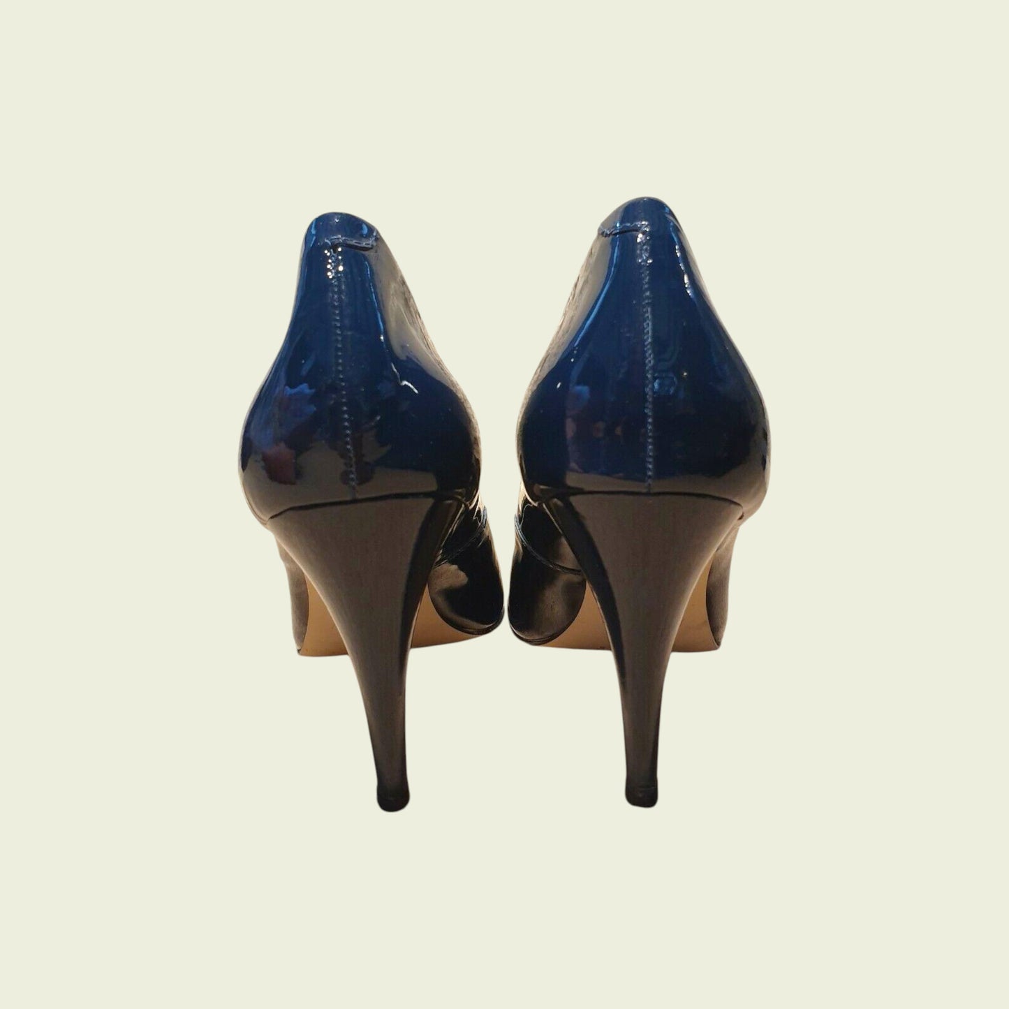 Pair of blue high-heeled shoes on a beige background