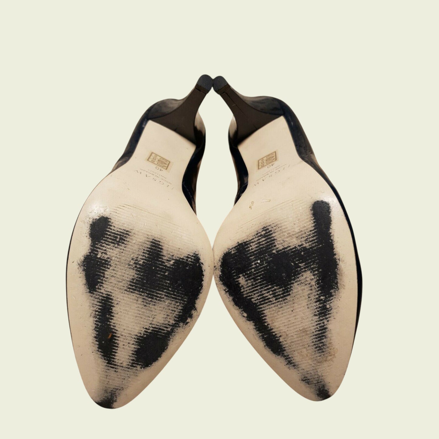 Pair of shoe soles with black markings on a beige background