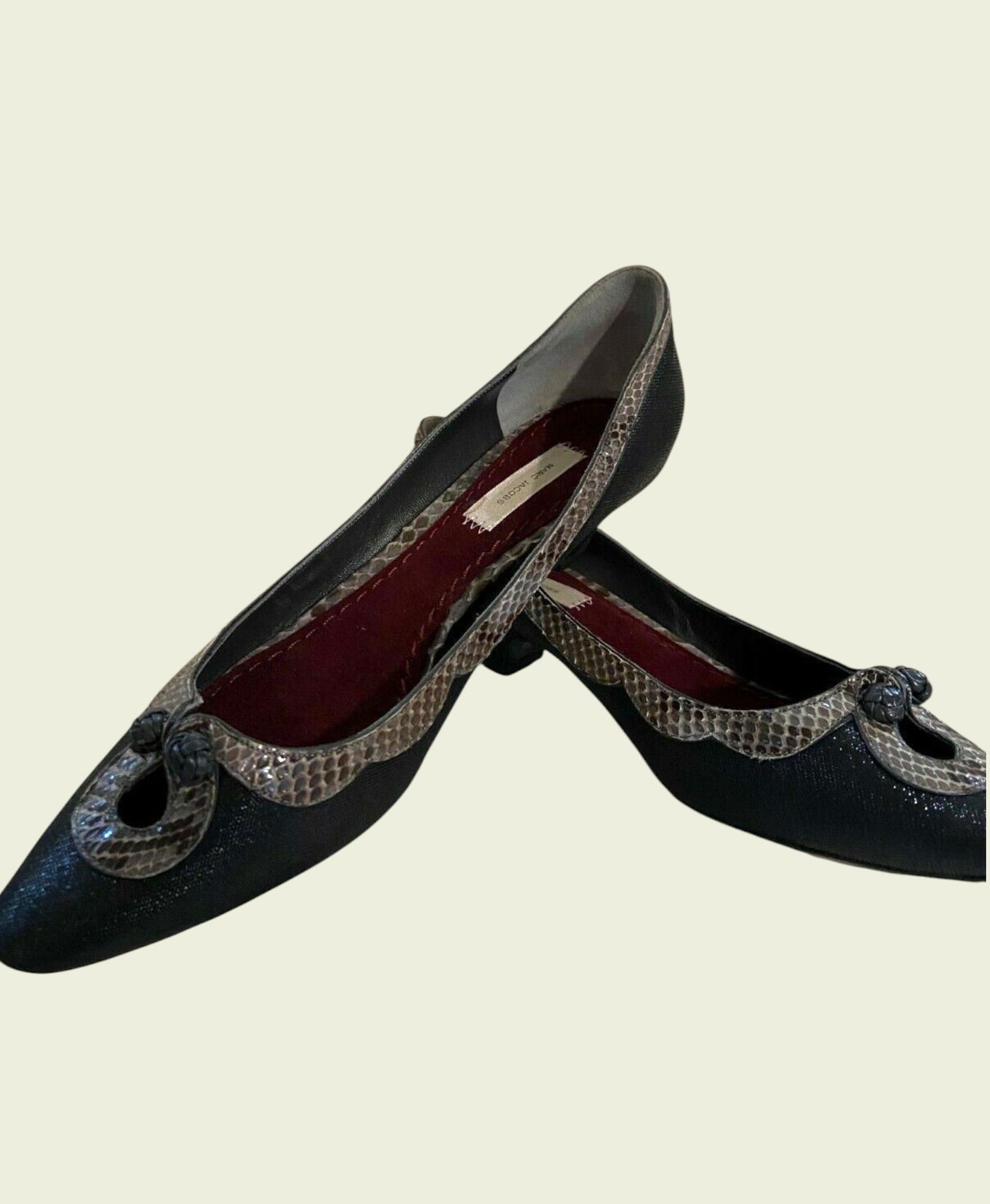 Pair of black shoes with decorative elements on a beige background