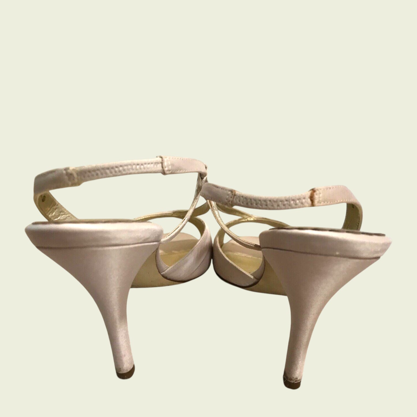 Pair of beige high-heeled shoes on a light background