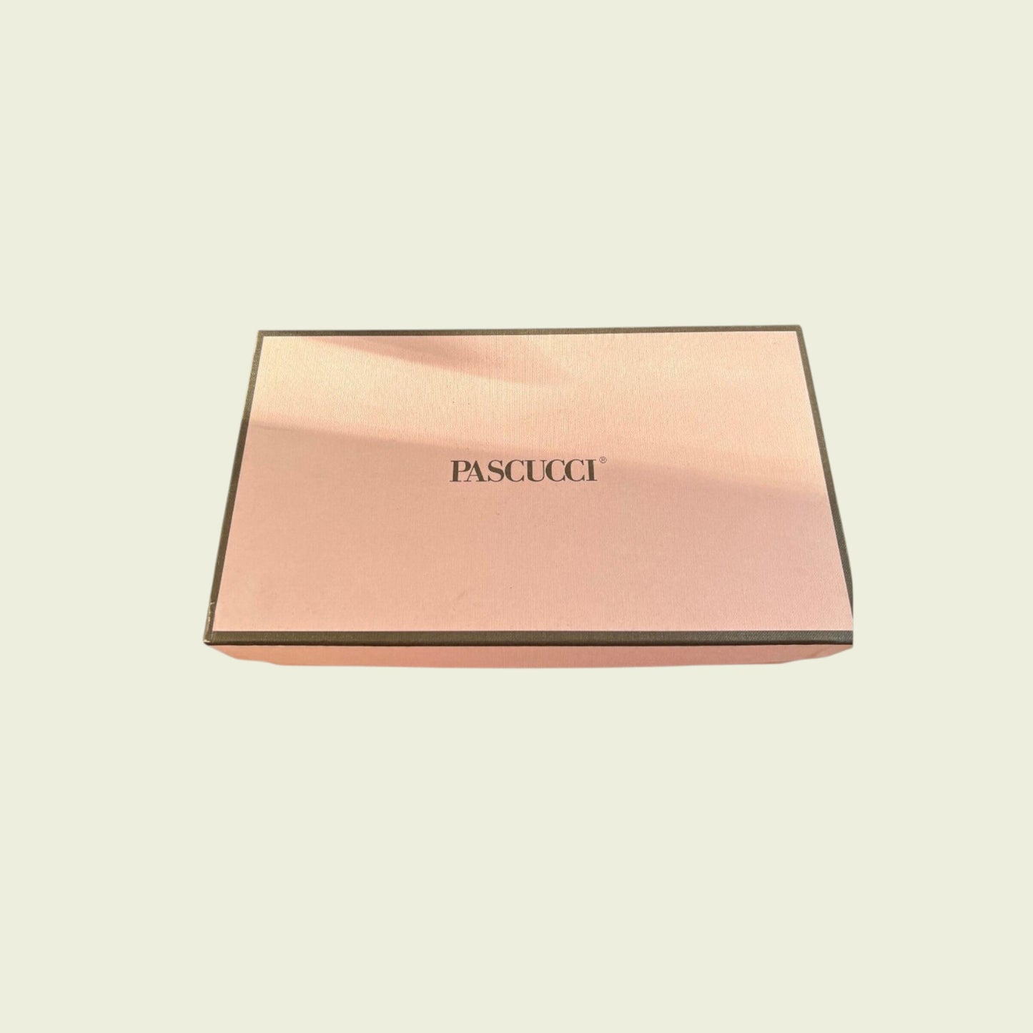 Rose gold box with 'Pascucci' branding on a beige background