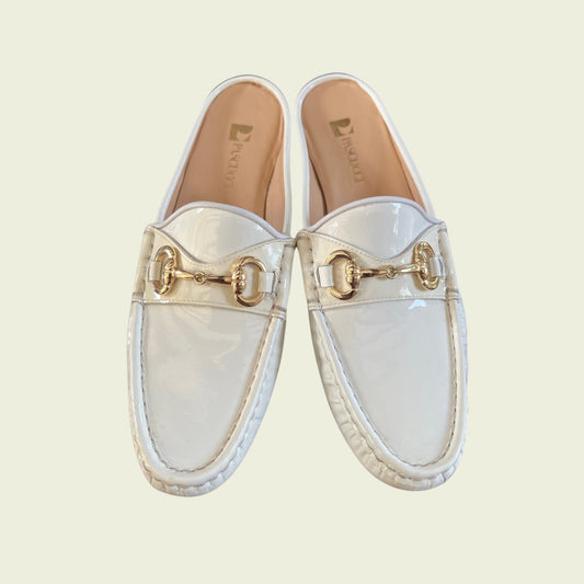 White loafers with gold accents on a light beige background