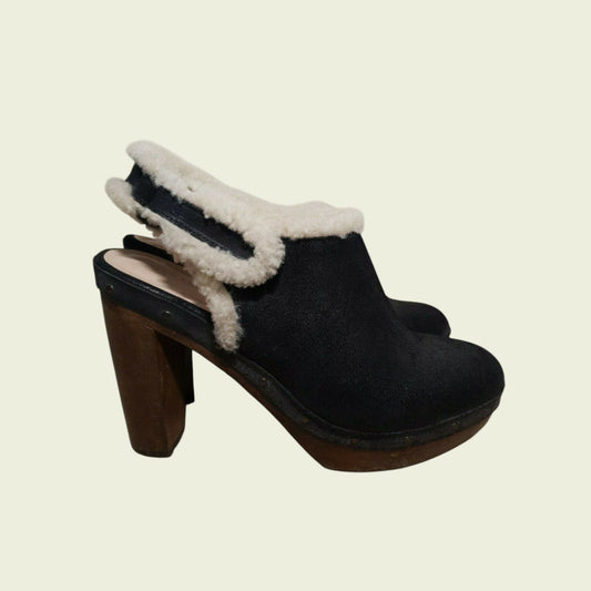 Black suede clog with white fur trim on a beige background