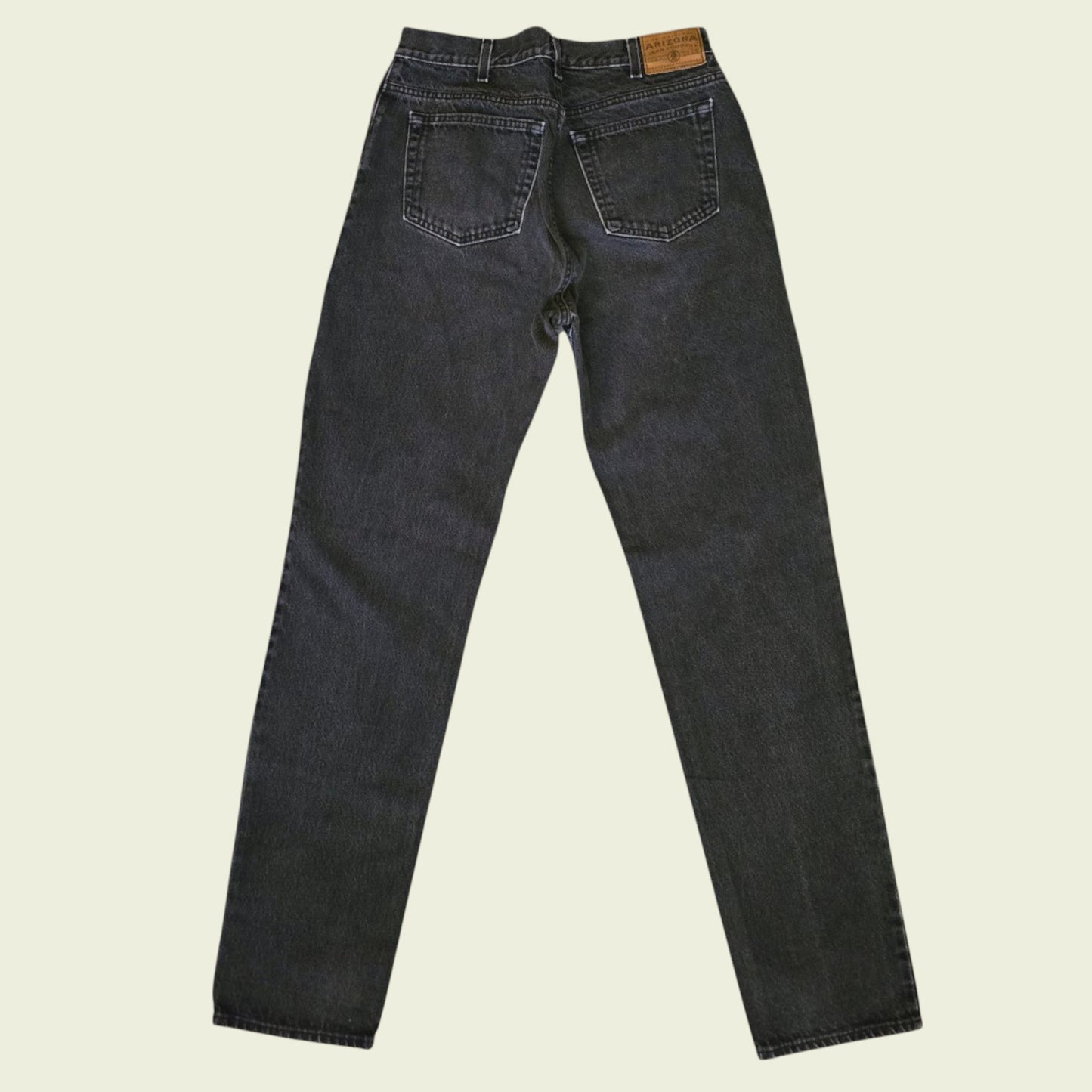 Pair of black jeans on a beige background