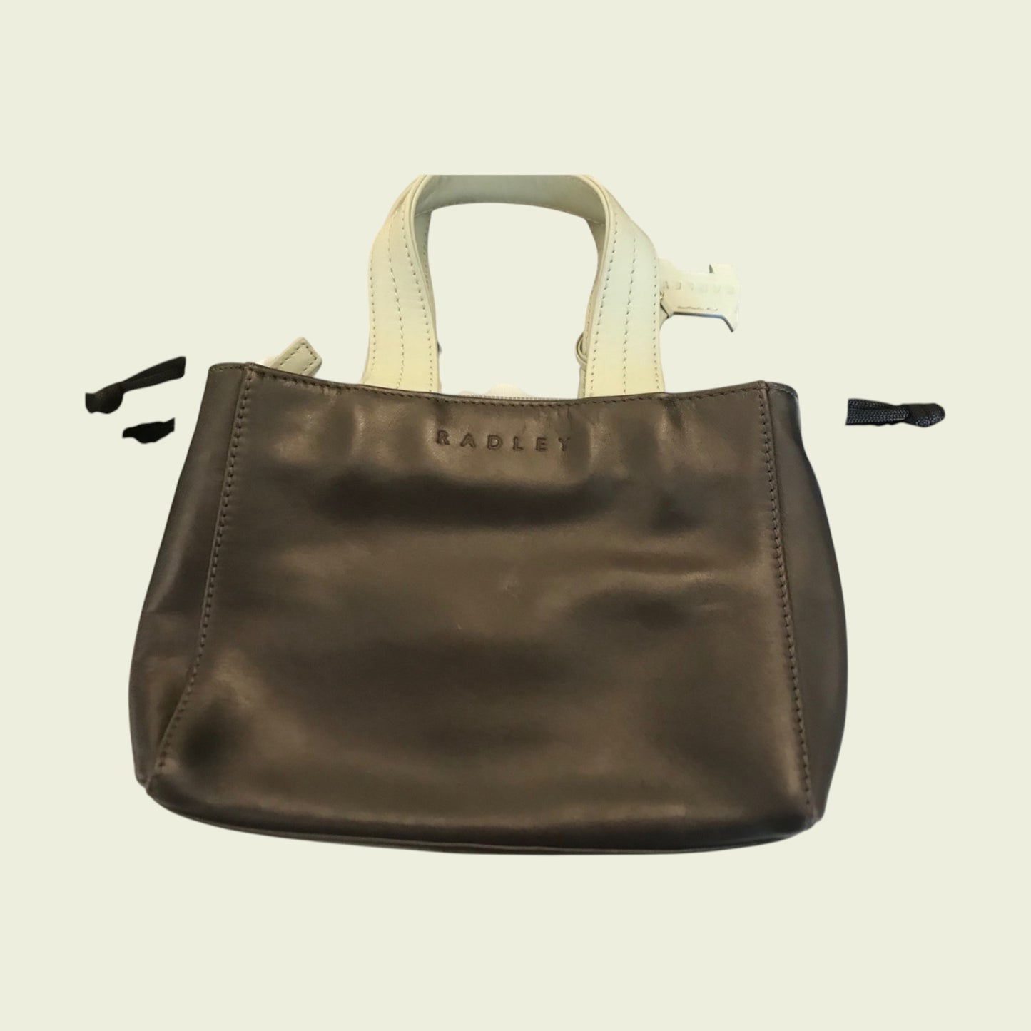 Brown leather handbag with 'Radley' branding on a beige background