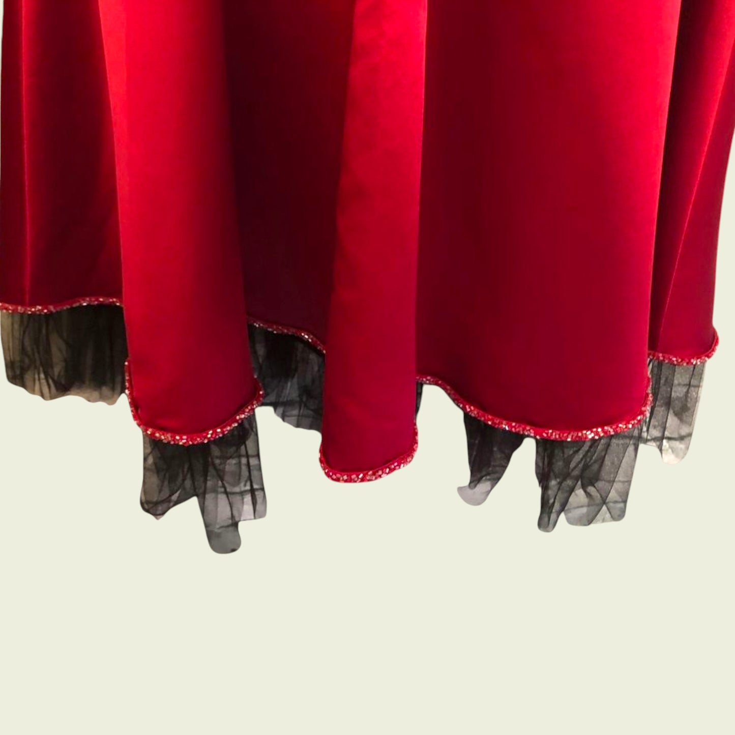 Hem line of red dress on beige background