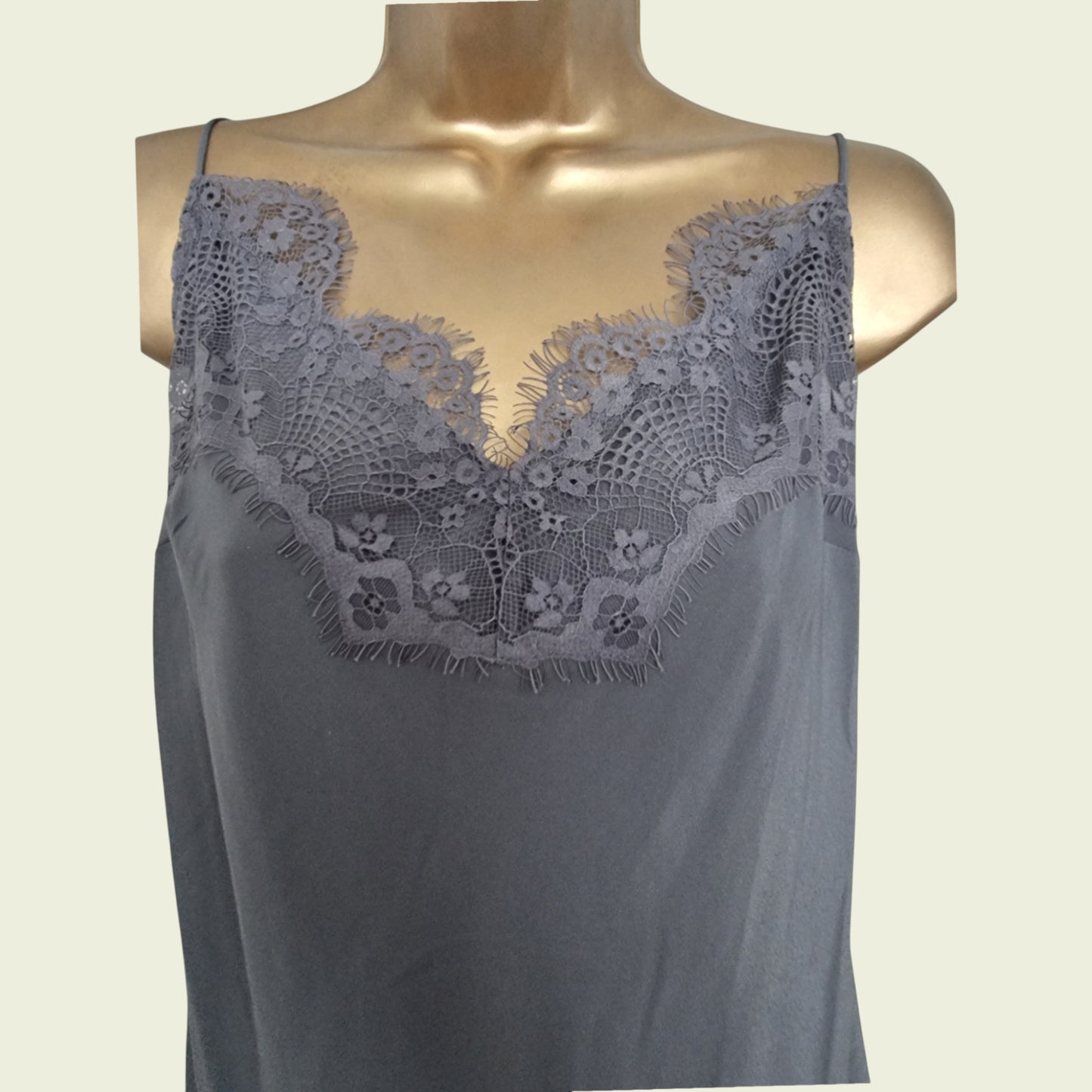 Gray lace-trimmed top on a mannequin against a beige background