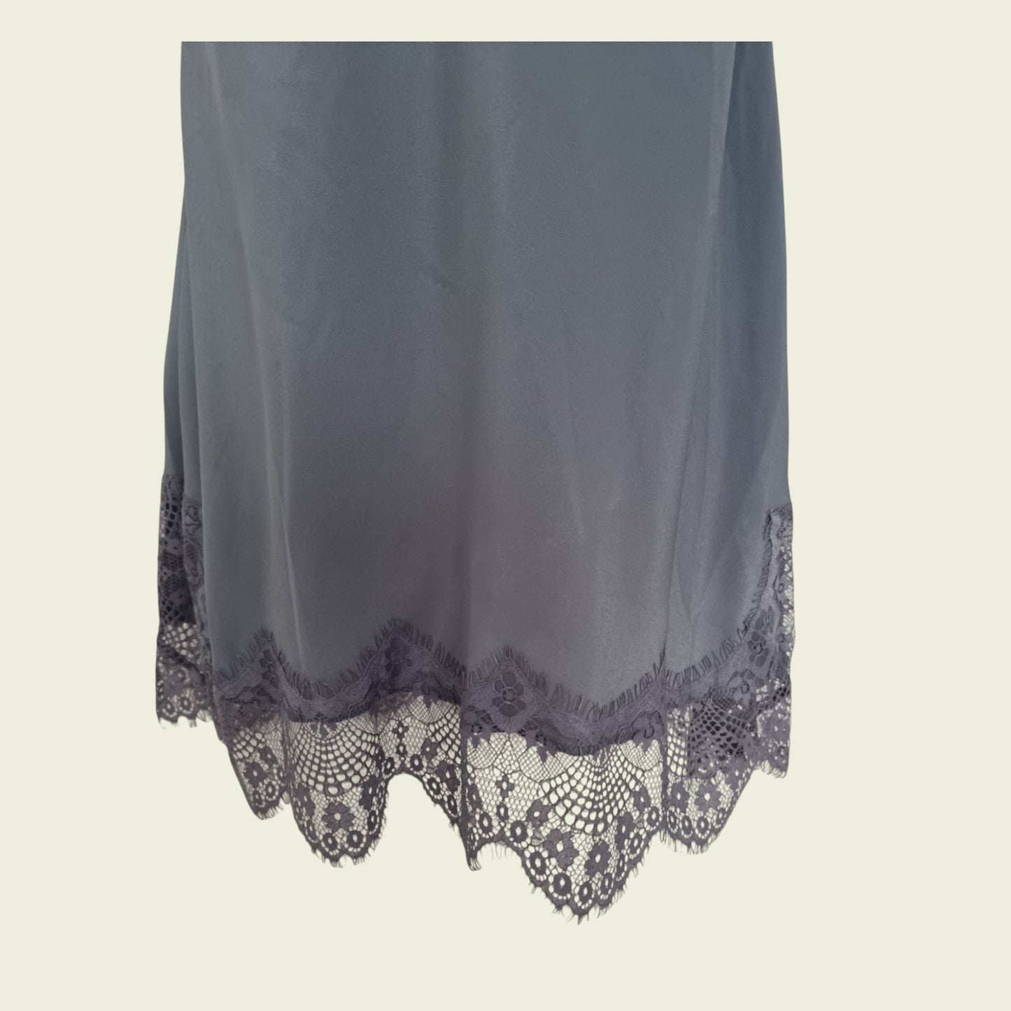 Gray fabric with lace trim on a beige background