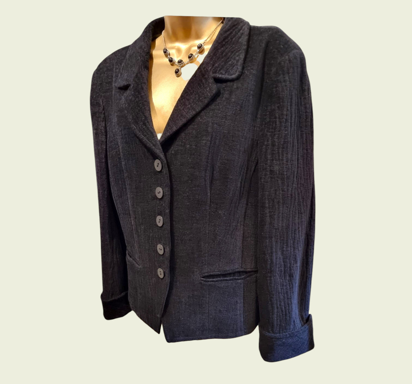 Black jacket on a mannequin against a plain background