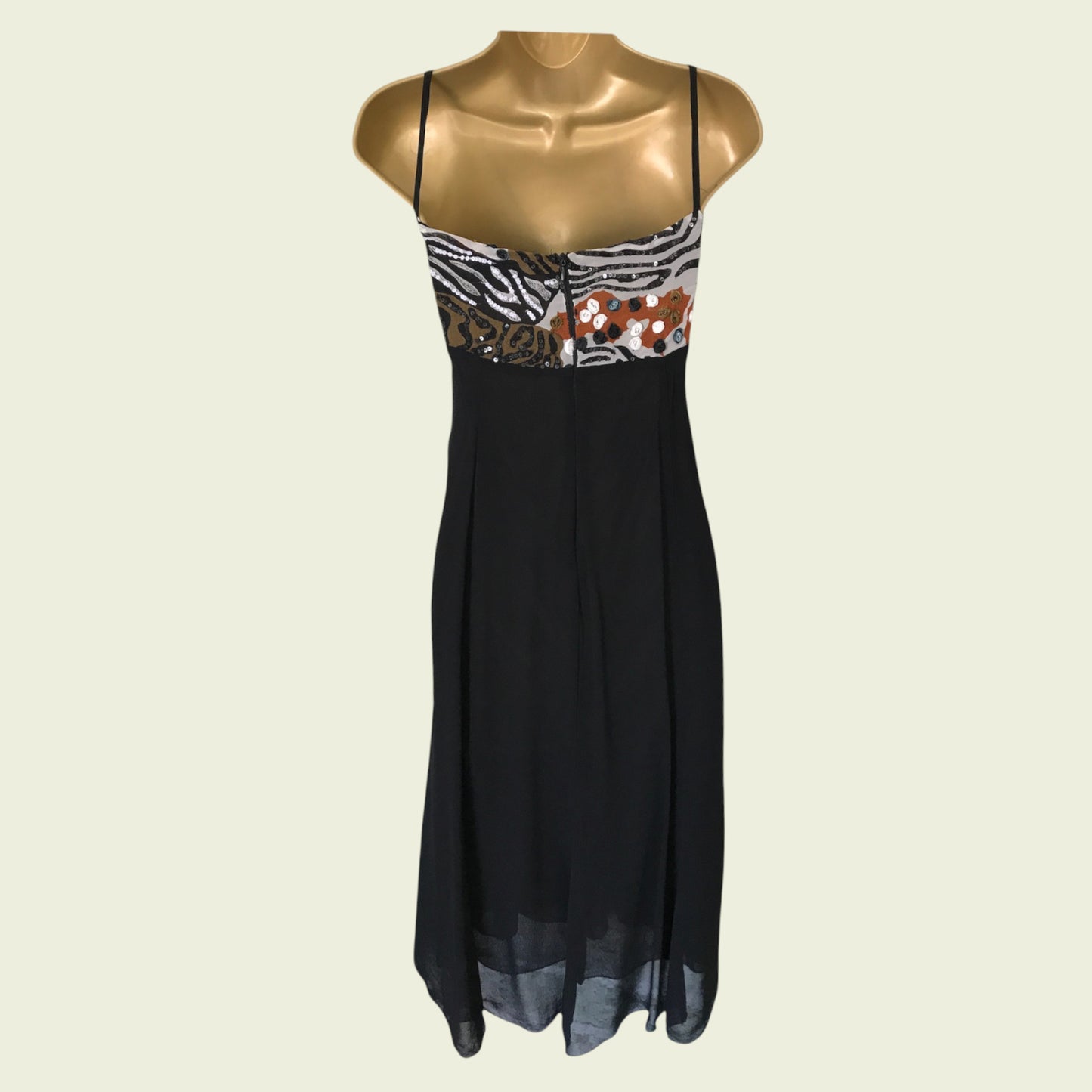 Black dress with zebra print and floral details on a mannequin against a beige background