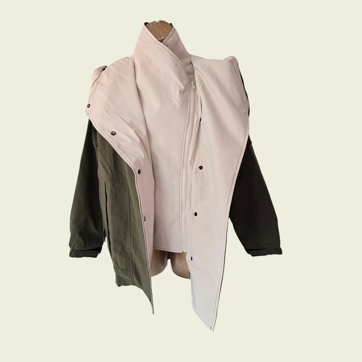 Khaki rain coat showing internal jacket on beige background