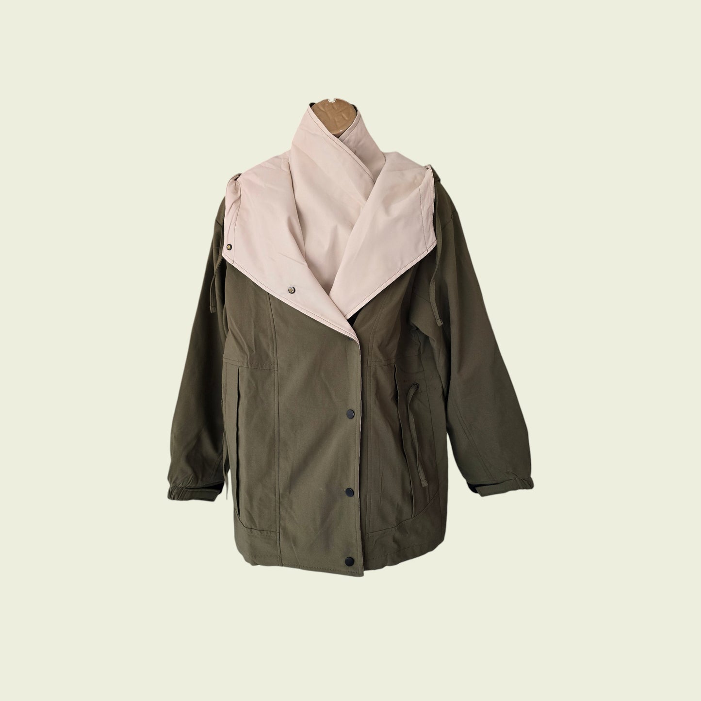 Khaki rain coat showing internal jacket on beige background