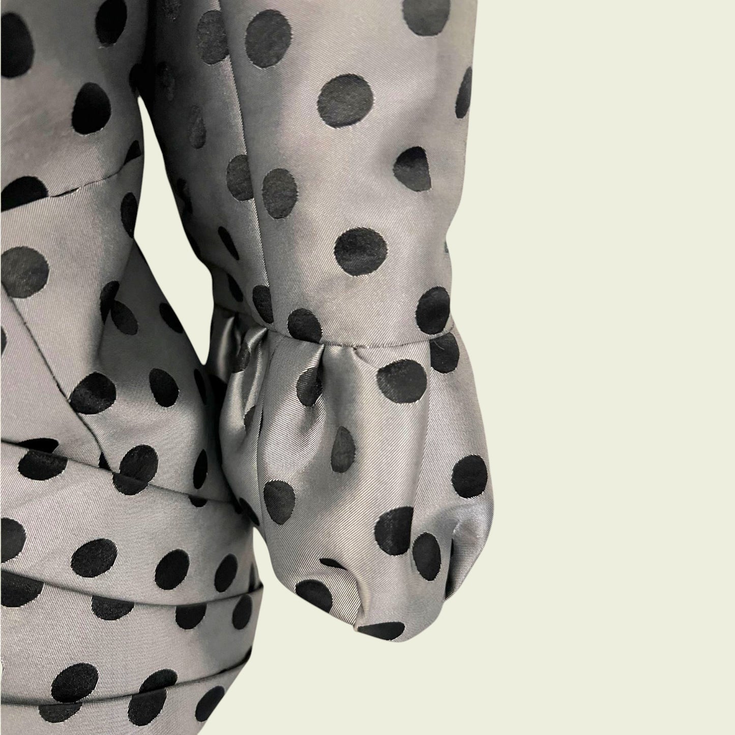 Gray blouse with black polka dots on a light beige background