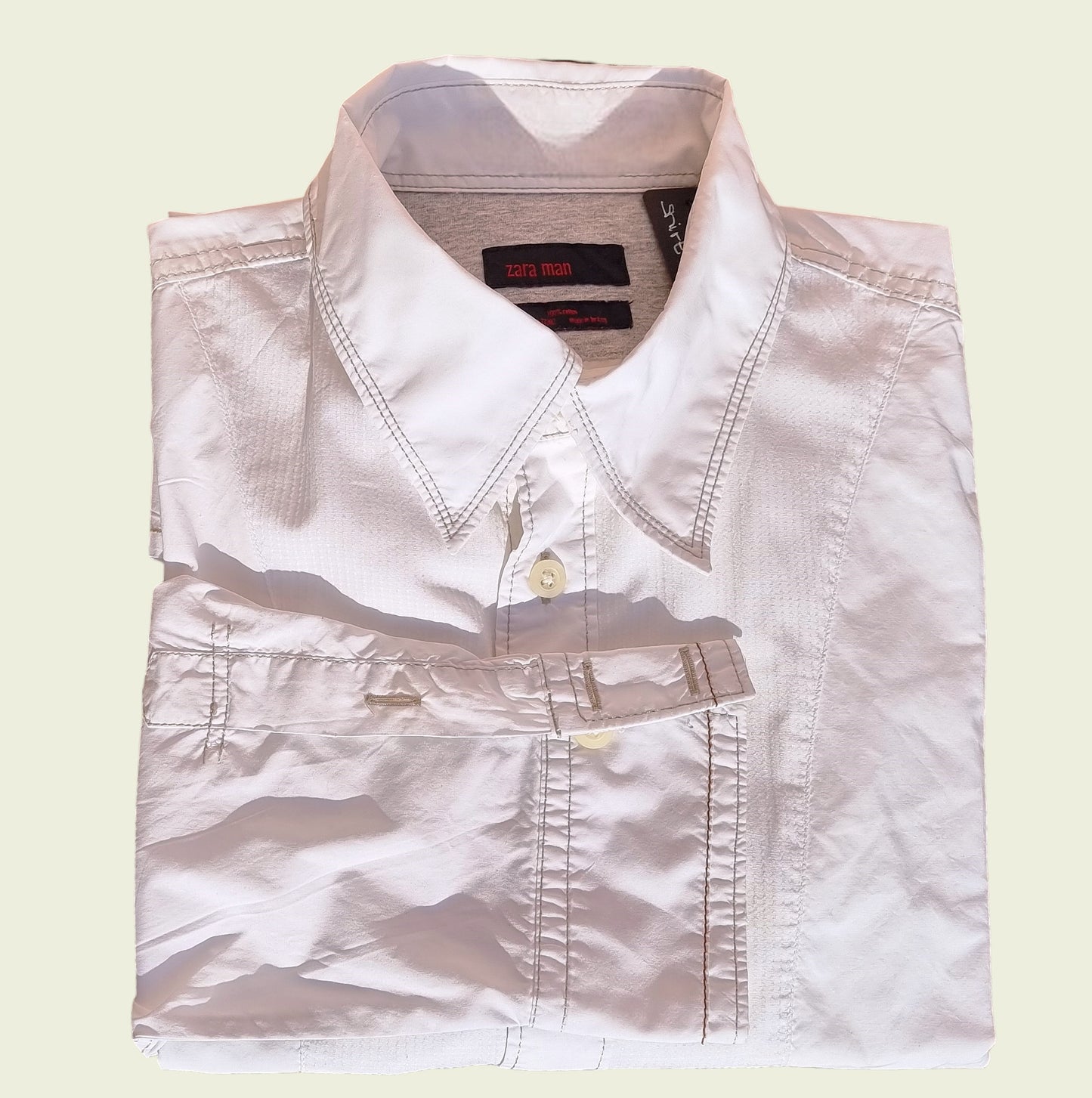Men's white pleated dress shirt on beige background