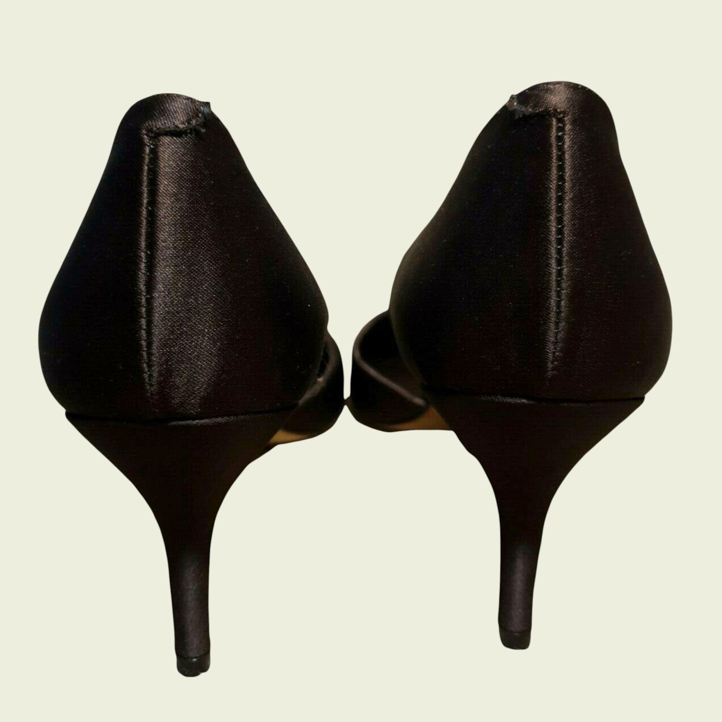 Pair of brown high-heeled shoes on a beige background