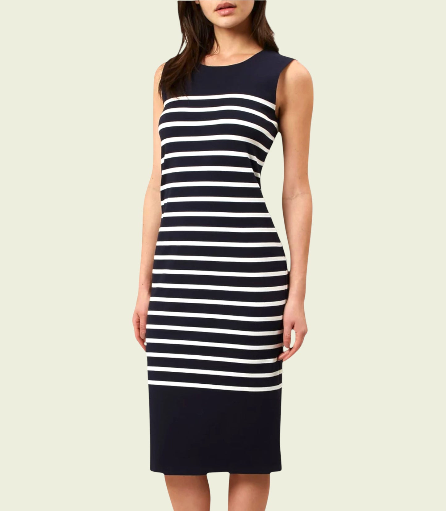 Woman wearing a navy and white striped dress on a beige background