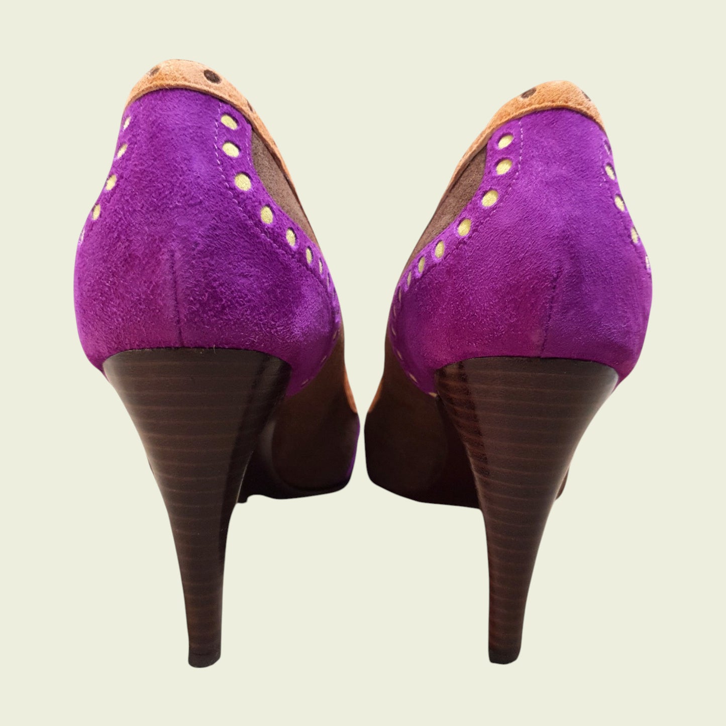 Purple high-heeled shoes with brown soles on a beige background