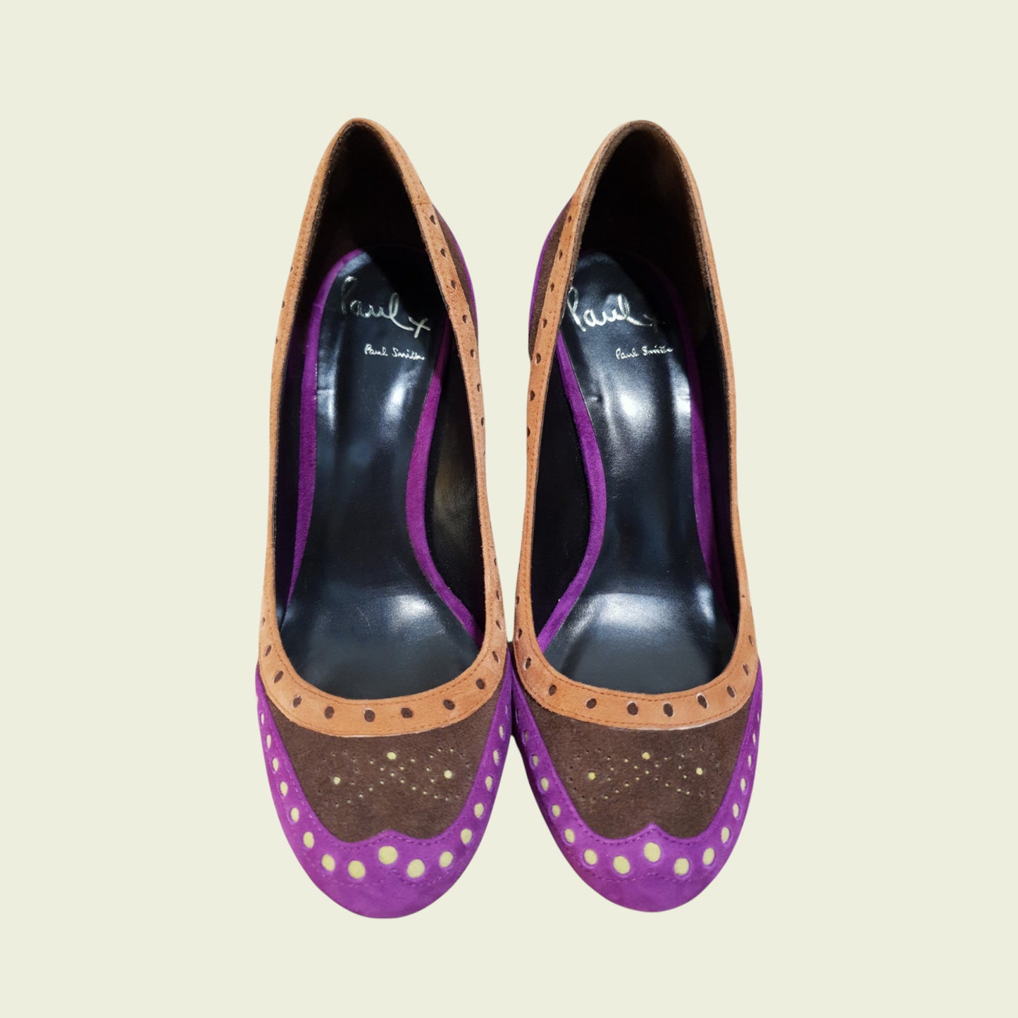 Pair of high-heeled shoes with purple and brown design on a beige background