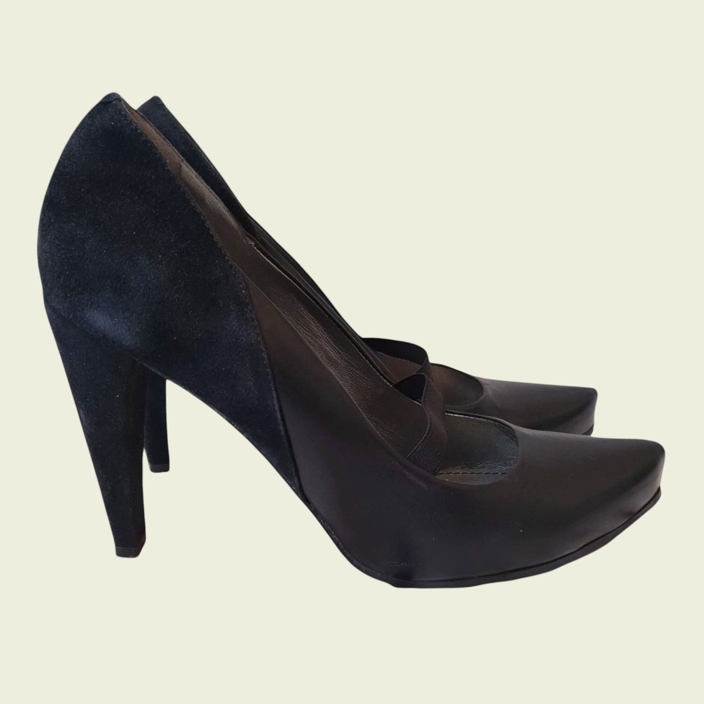 Pair of black high-heeled shoes on a beige background