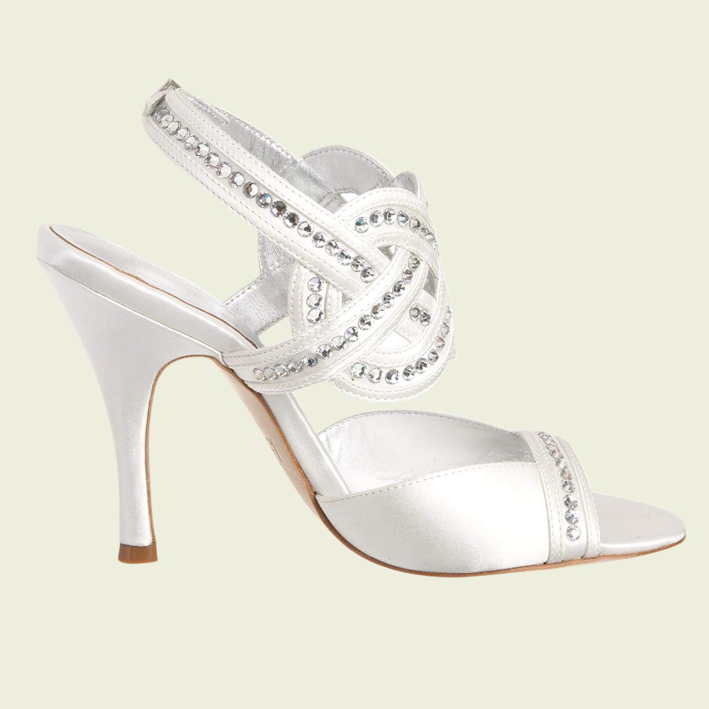 White high-heeled shoe with crystal embellishments on a light green background