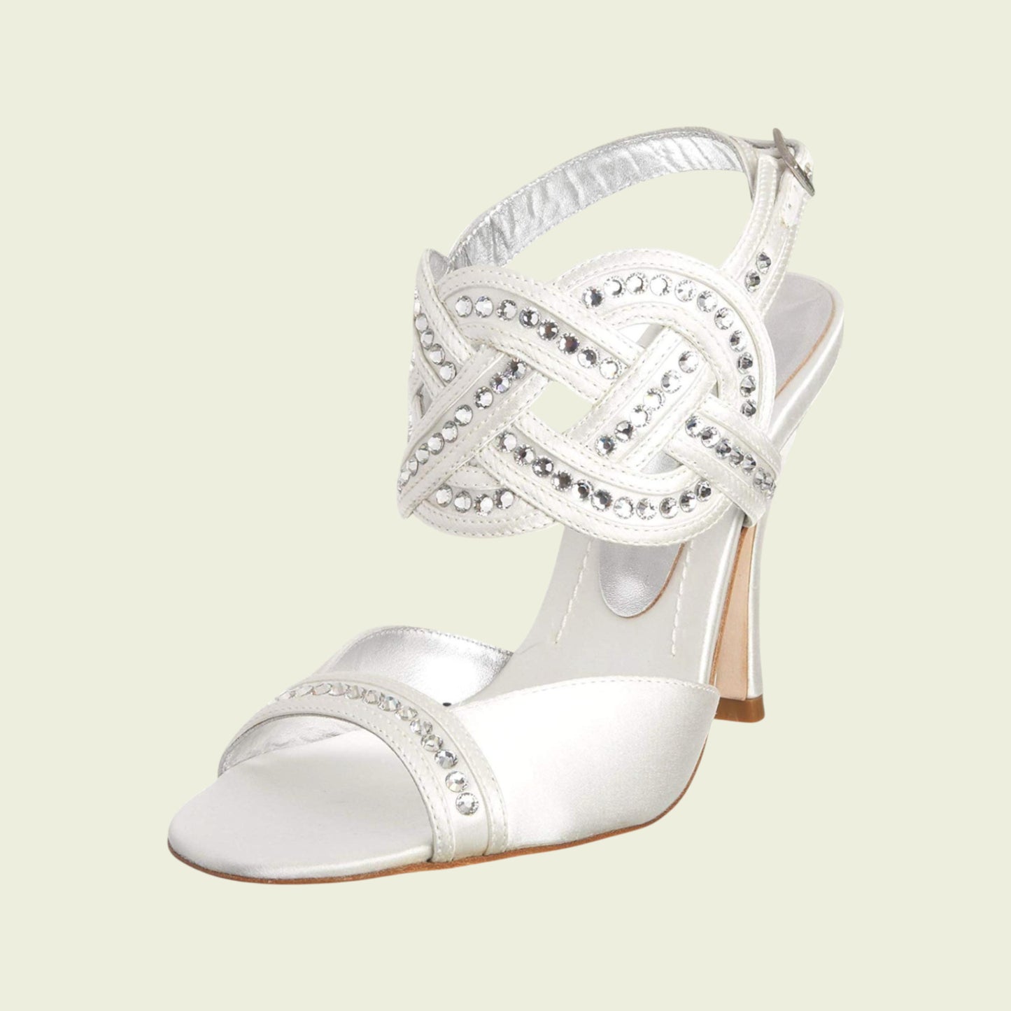 White high-heeled shoe with decorative strap on a light beige background