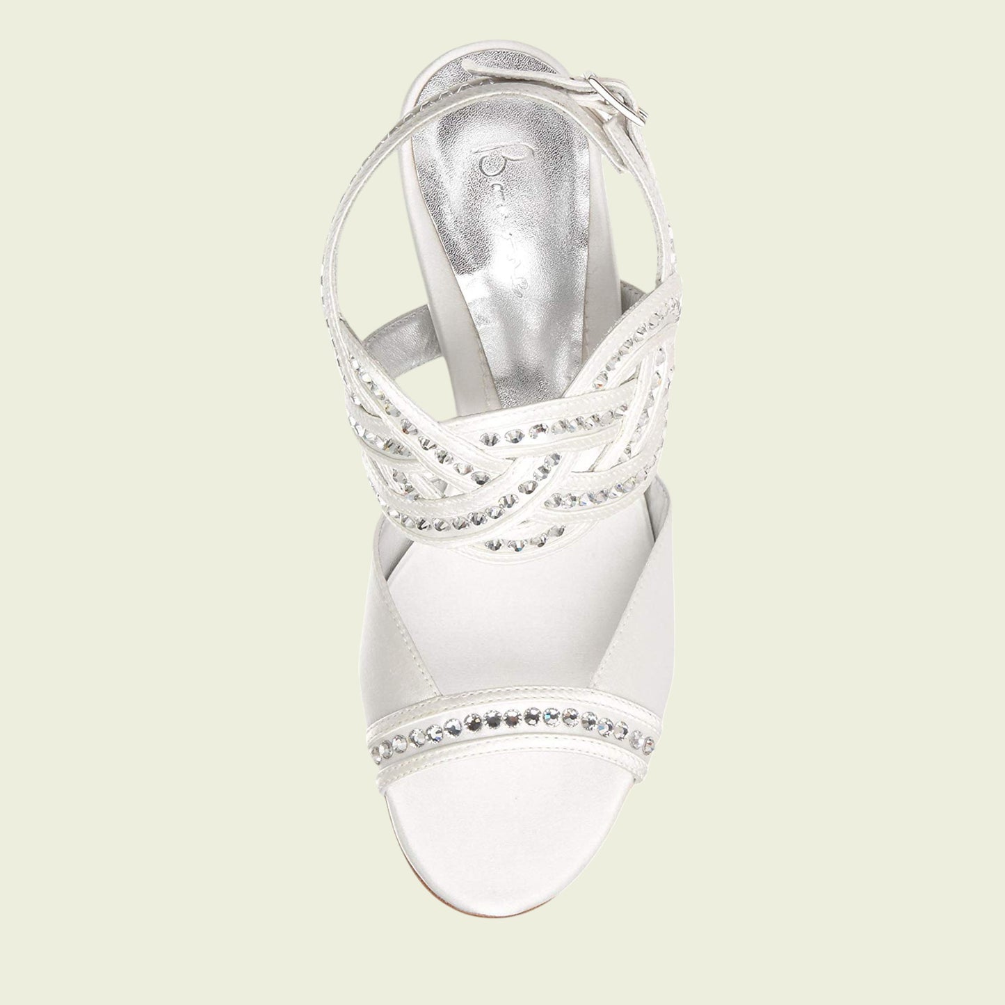 White sandal with embellishments on a light beige background