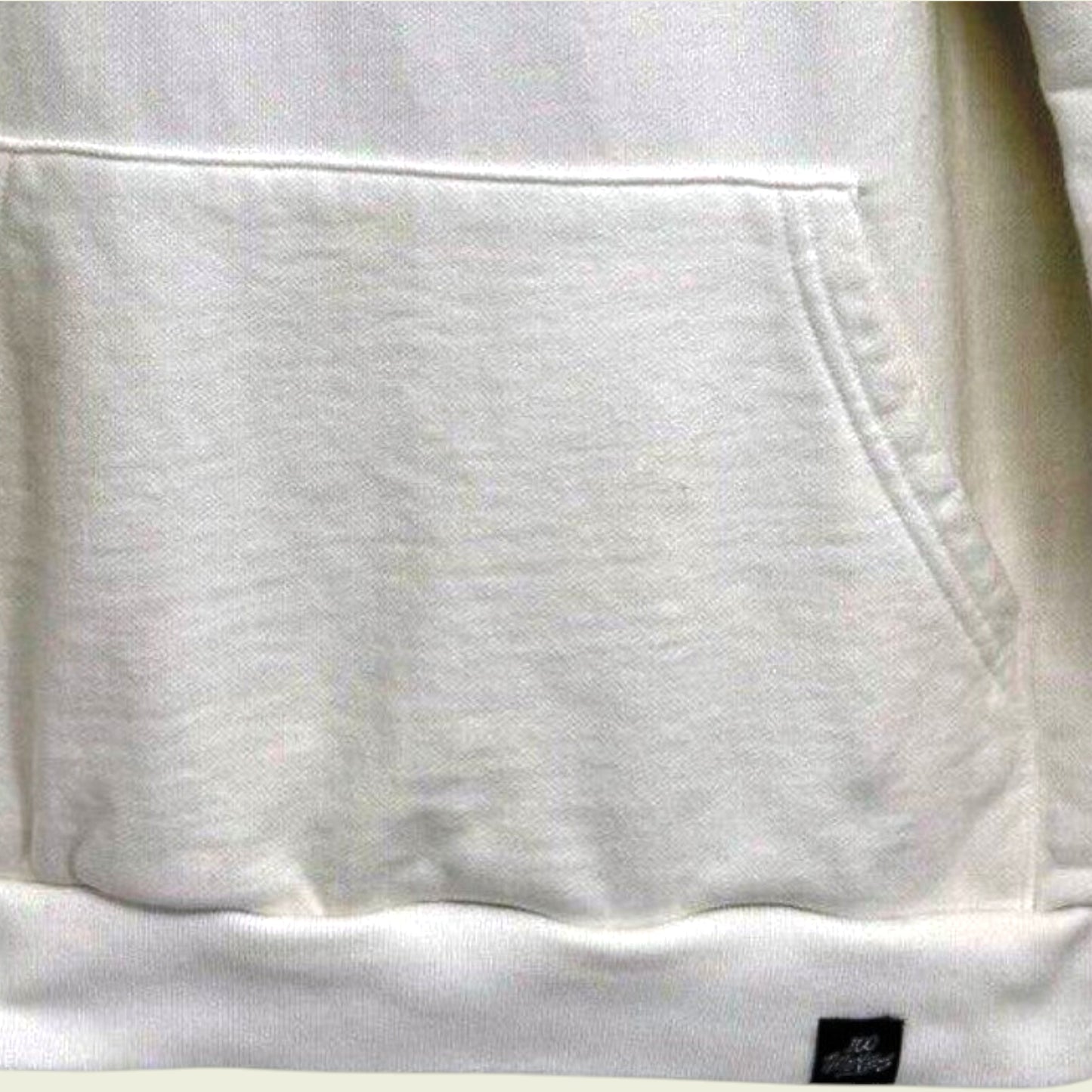 Close-up of a white hoodie with a pocket and brand logo.