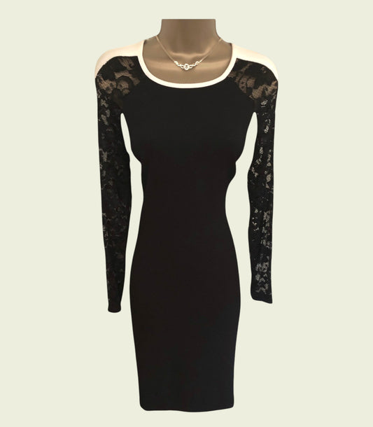 Black dress with lace sleeves on a mannequin against a beige background
