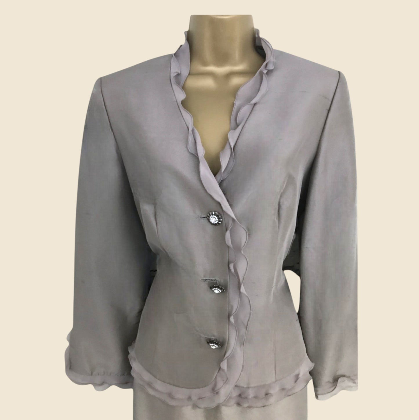 Gray blouse with buttons on a mannequin against a beige background