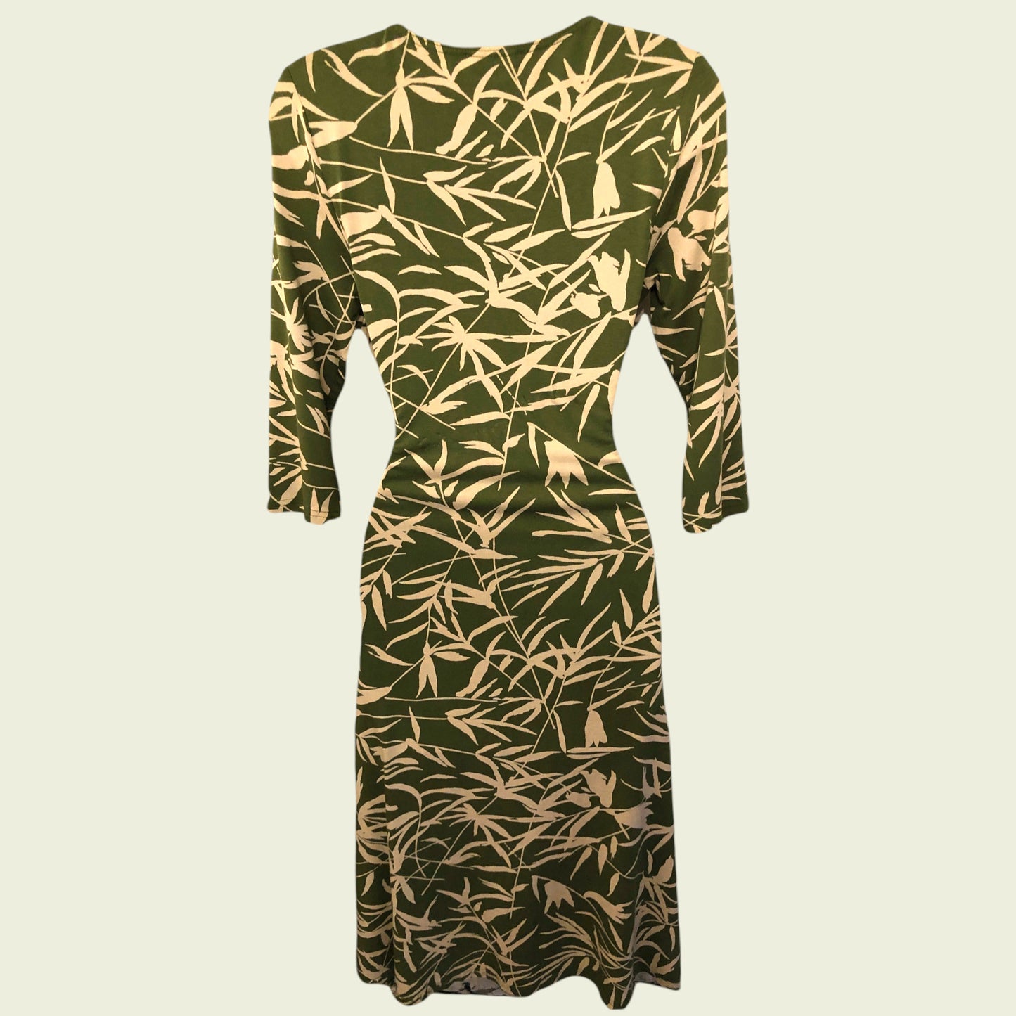 Green dress with beige leaf pattern on a beige background