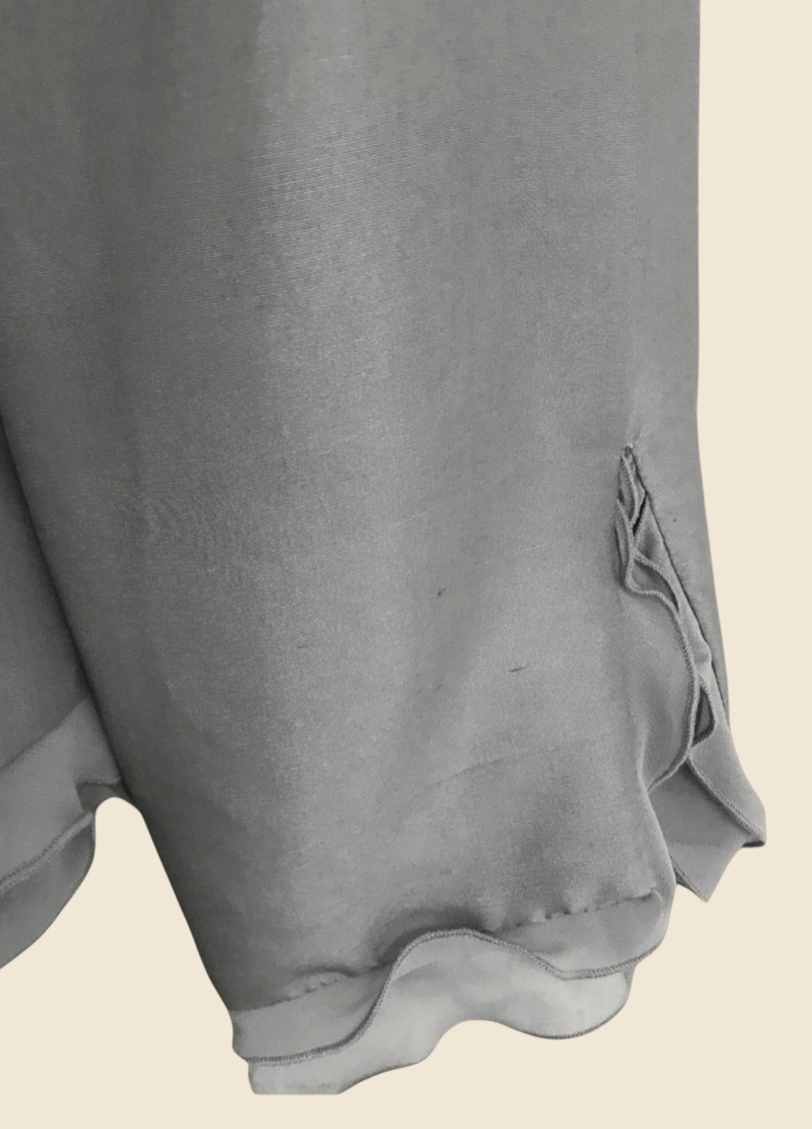Close-up of a gray garment sleeve with a beige background