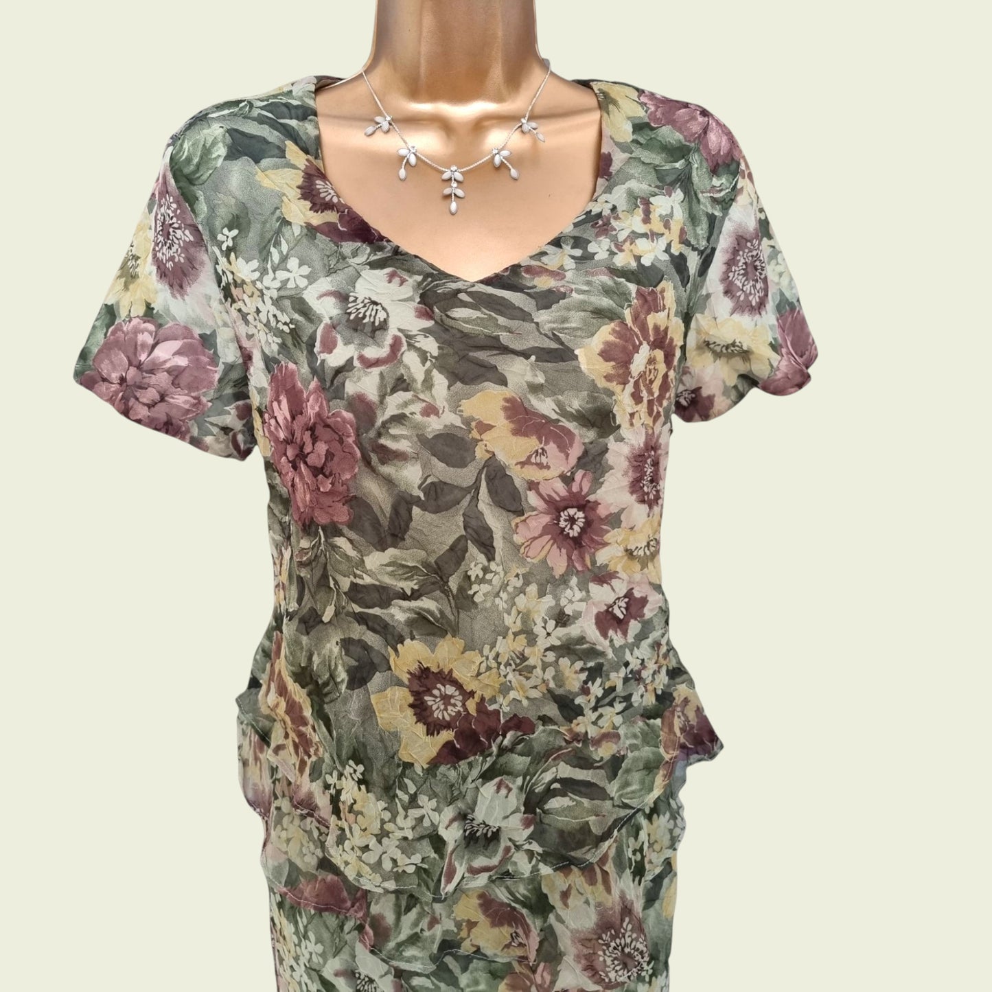 Floral patterned top on a mannequin against a plain background