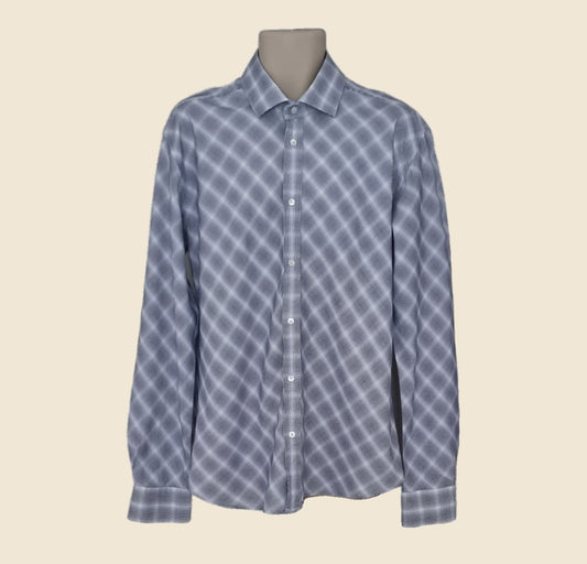 Blue checkered shirt on a mannequin against a beige background