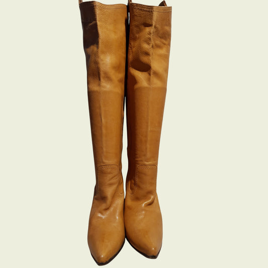 Pair of tan knee-high boots on a beige background