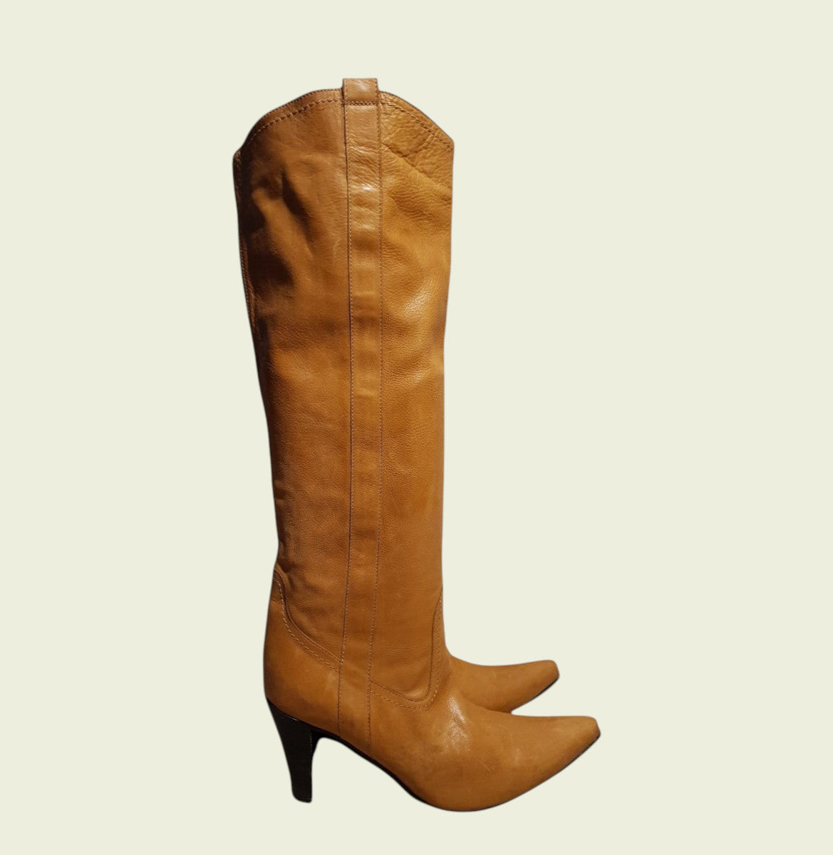Tan leather knee-high boot on a beige background