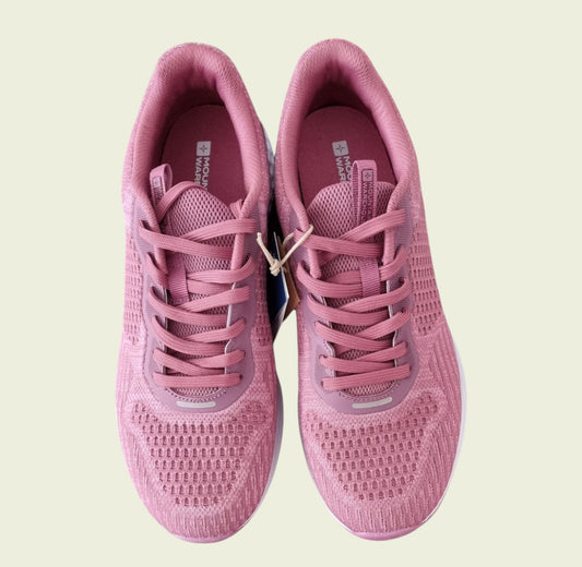 Pair of pink running shoes on a light beige background