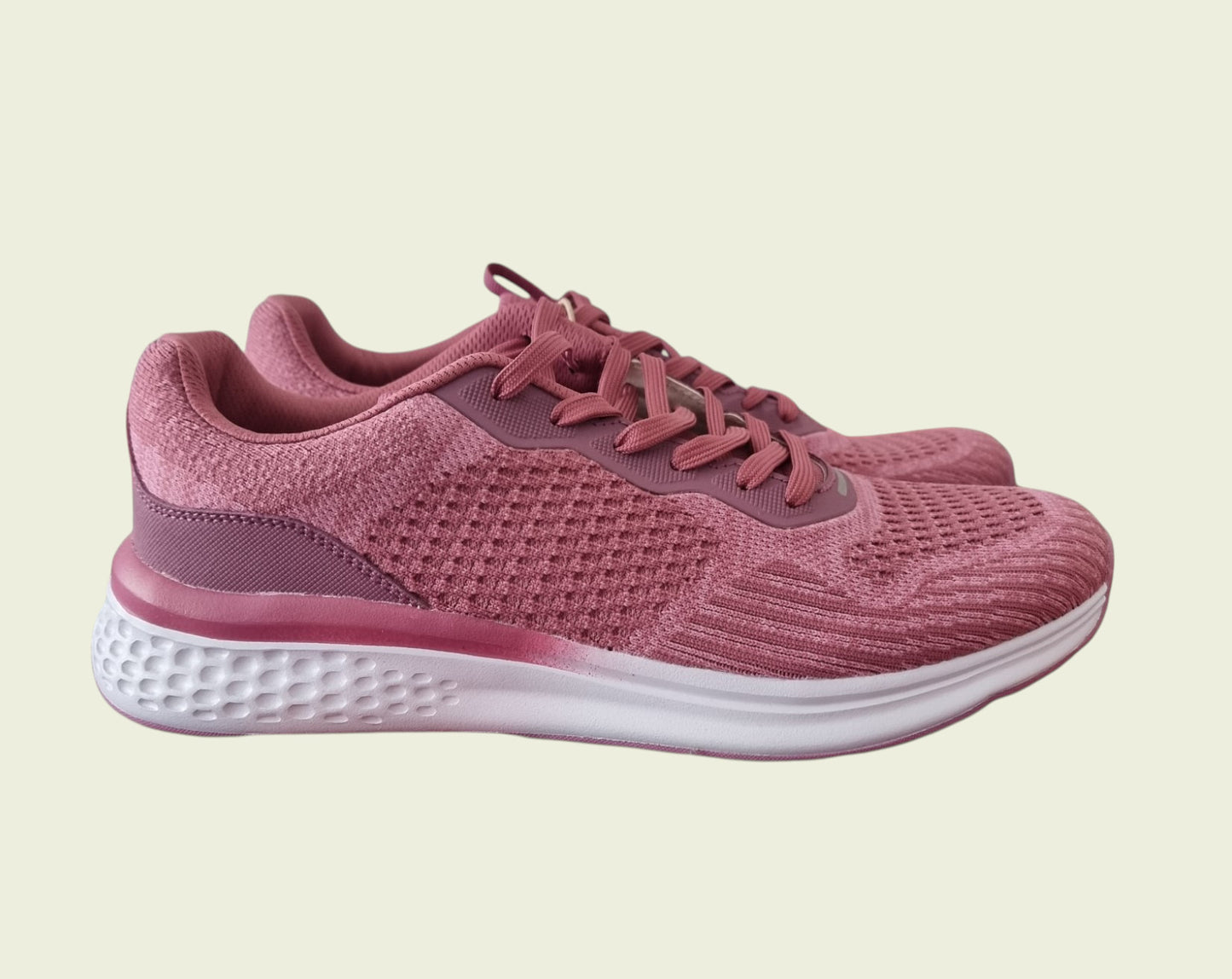 Pink running shoe on a beige background
