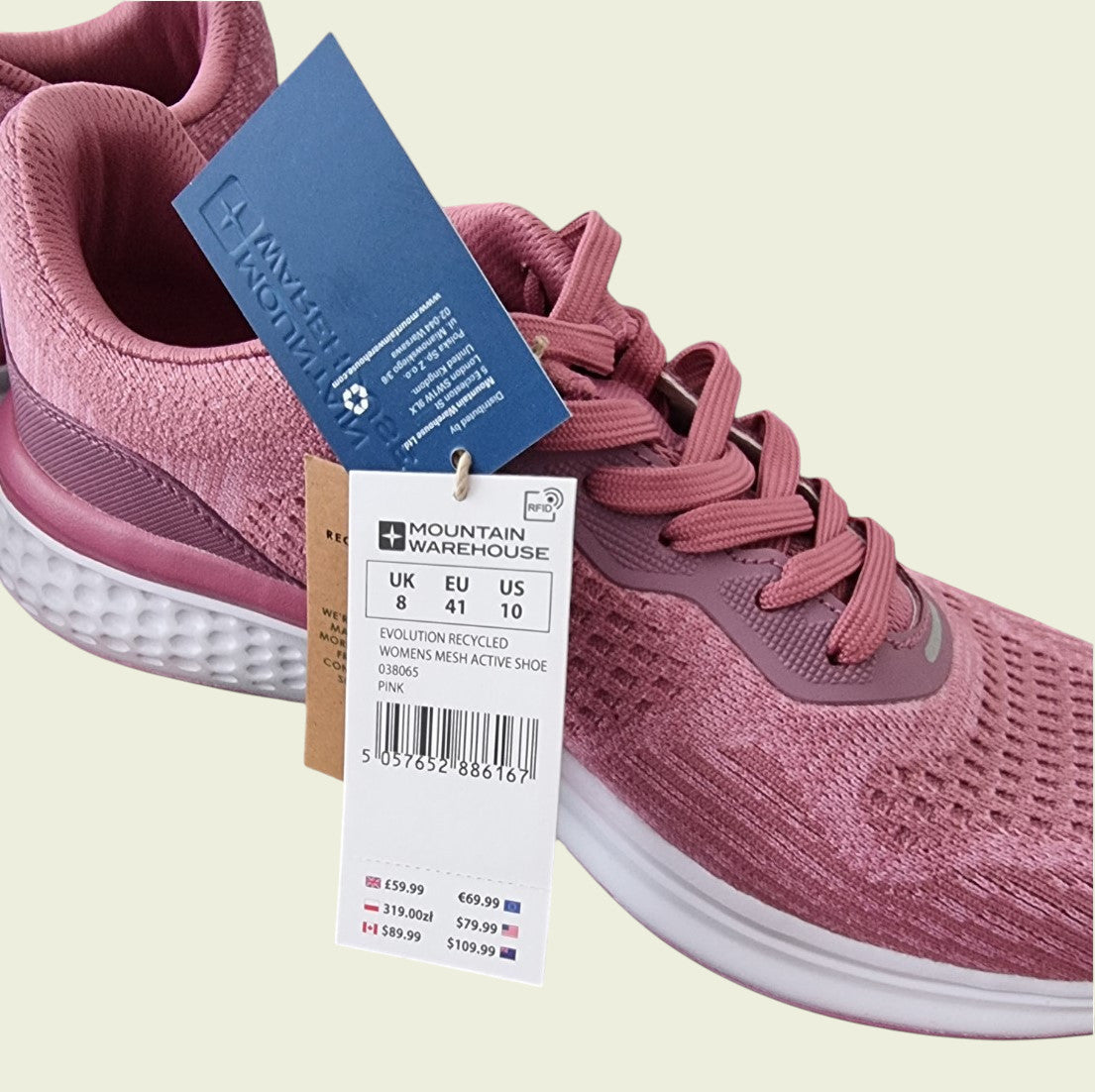 Pink running shoe with a tag on a beige background