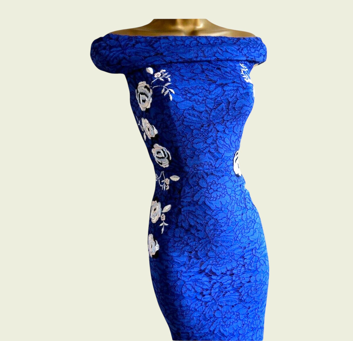 Blue lace dress with floral patterns on a beige background